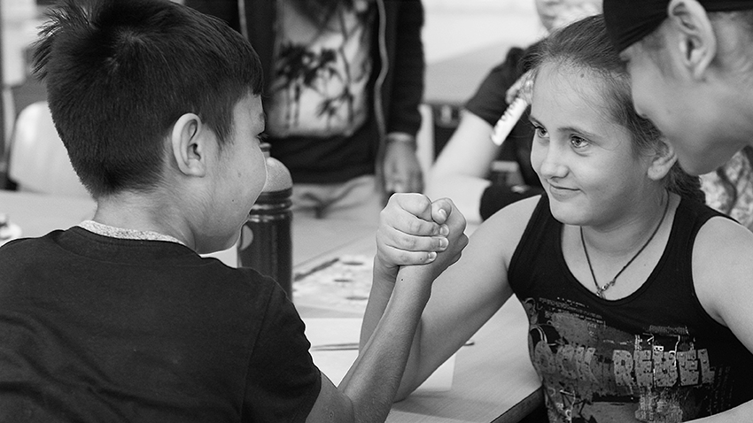 Ein Mädchen und ein Junge machen Armdrücken