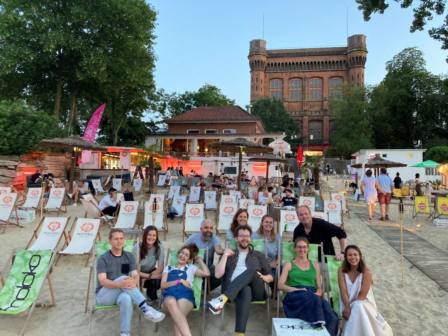 Die Slammer:innen Janina Mau, Sadaf Zahedi, Aidin Halimi, Yannik Steinkellner, Miedya Mahmod und Henrik Szanto in Beach Chairs sitzend mit drei Kolleginnnen der Europaabteilung und des EuropaPunktBremen und Sebastian Butte vom Slammerfilet