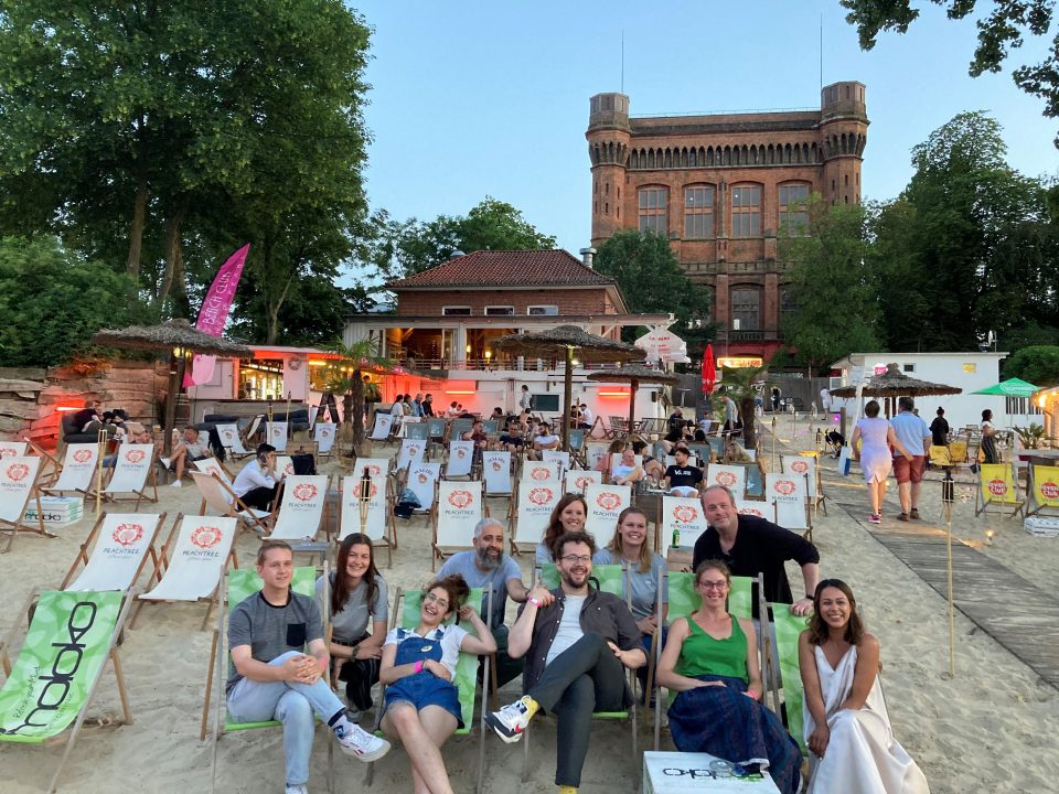 Die Slammer:innen Janina Mau, Sadaf Zahedi, Aidin Halimi, Yannik Steinkellner, Miedya Mahmod und Henrik Szanto in Beach Chairs sitzend mit drei Kolleginnnen der Europaabteilung und des EuropaPunktBremen und Sebastian Butte vom Slammerfilet